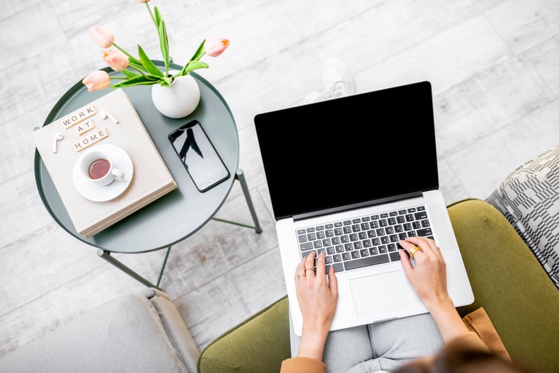 Aerial view of a remote workspace with computer, coffee and cell phone.