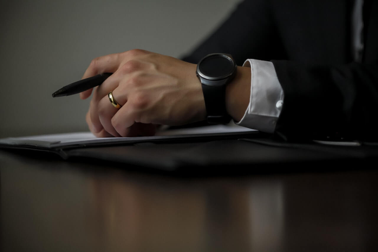 Businessperson writing with a pen in hand