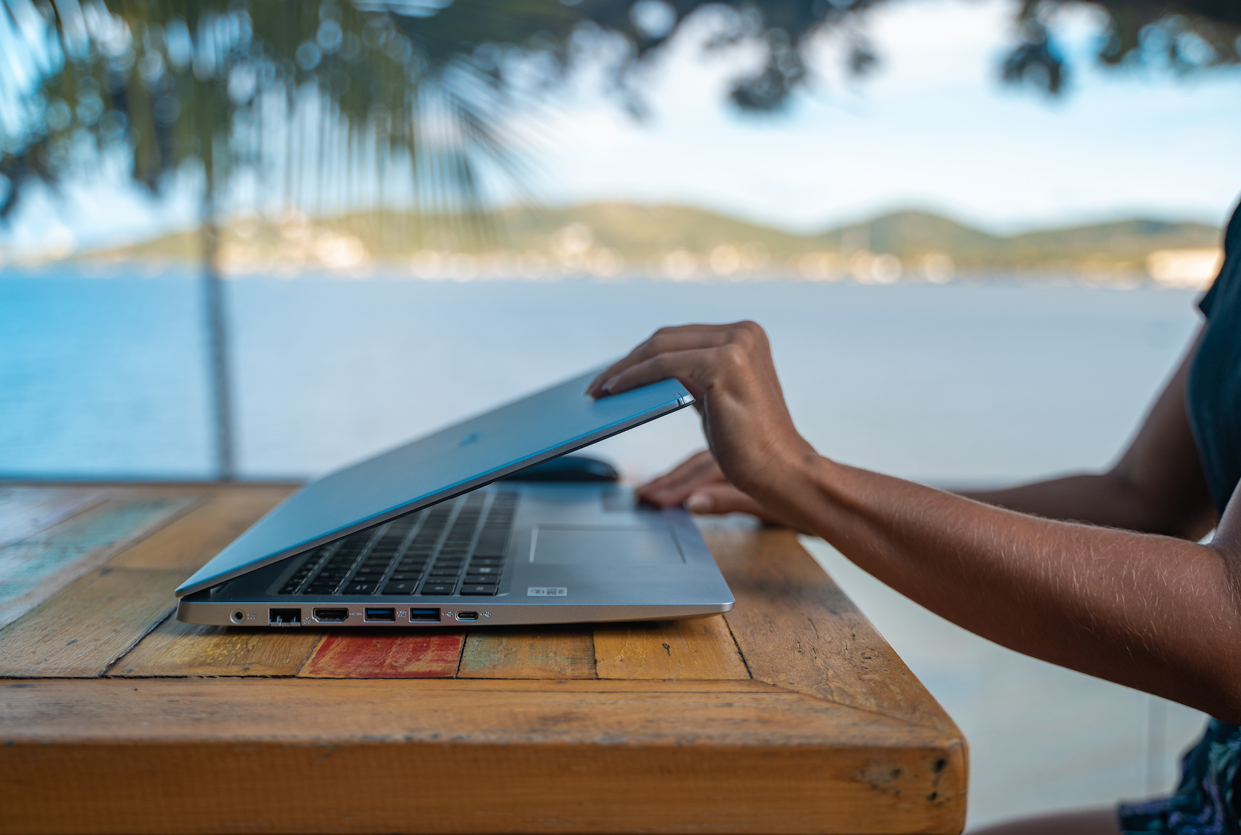 Person using laptop on beach vacation